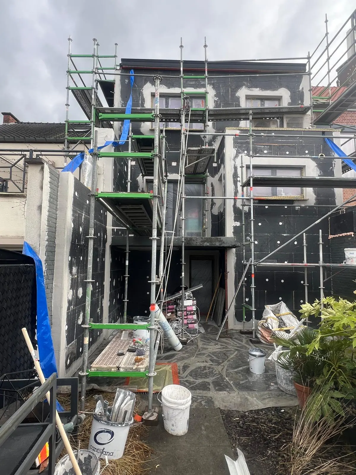 Gevel met isolatieplaten en stelling tijdens een renovatie